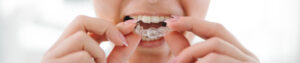 Mulher colocando modelo dental na boca